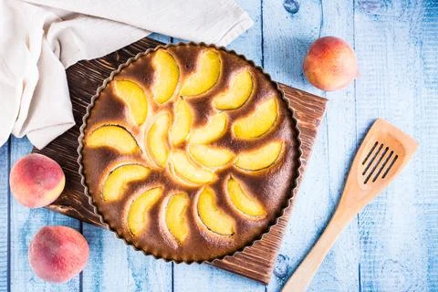 Ready fresh peach pie in a baking dish on the table. Homemade dessert. Top vi Stock Photos