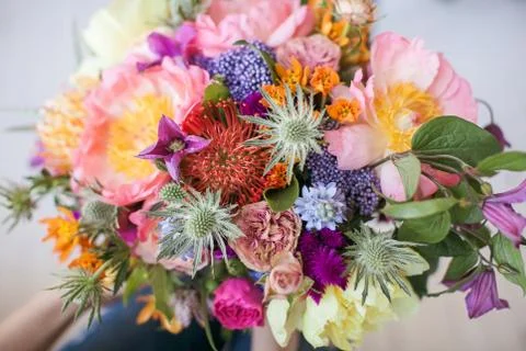 A ready-made bouquet of different colored flowers, peonies, roses and other e Stock Photos