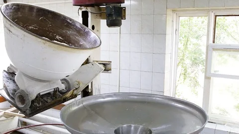Ready-made dough in the bakery from a large bowl of knead is turned into a bowl Stock Footage 128304717