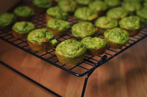 Ready-made small green muffins with spinach on a baking sheet Stock Photos