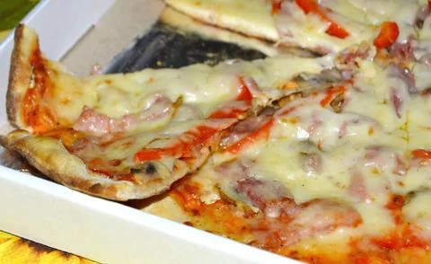 Ready pizza with ham in a hill. Stock Photos