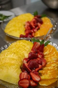 Ready-to-serve sliced fruit platter with pineapple, strawberries, and orange Stock Photos