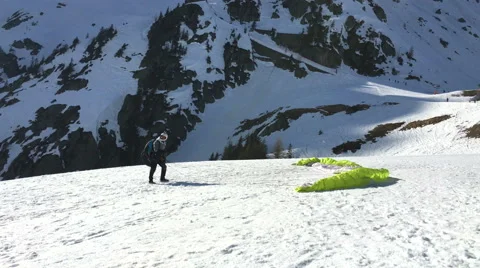 Ready to skyjump from a snowcovered mountain in Chamonix - green parachute Stock Footage 62177245