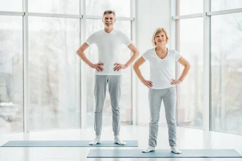 Ready to start training. Beautiful elderly couple standing in a spacious whit Stock Photos