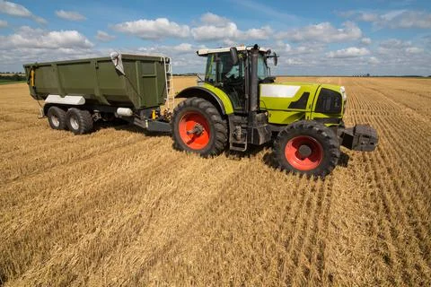 Ready to work green tractor with a loader trailer for the new harvest of crop Stock Photos