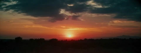 Real anamorphic sunset with a cloudy sky, a mountain on the horizon Stock Footage 279305136