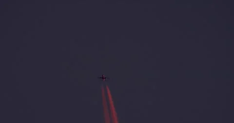 Real Authentic Distant Jet With Red Contrail At Sunset Slow Motion Static Shot Stock Footage 329557130