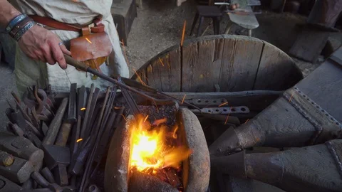 Real blacksmith working with blacksmith furs in forge. Stock Footage 108825400