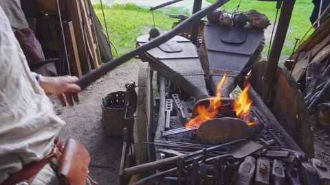 Real blacksmith working with blacksmith furs in forge. Stock Footage 108825665