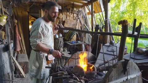 Real blacksmith working with blacksmith furs in forge. Stock Footage 108825866