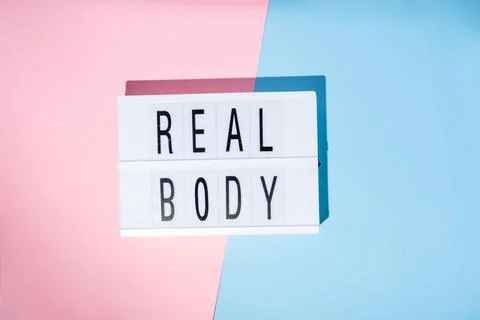 Real Body text on the lightbox. Concept of feminism on a blue and pink Stock Photos