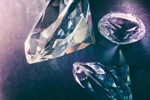 Real diamond stone on dark background. Diamond jewelry theme. Stock Photos