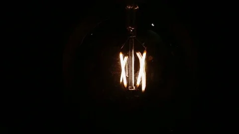 Real Edison light bulb flickering. Vintage filament Edison light bulb. Close up. Stock Footage 75473584