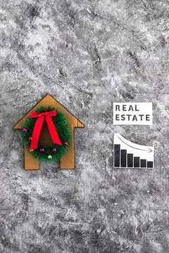 Real Estae text and graph with stats going down next to cardboard house wit.. Stock Photos