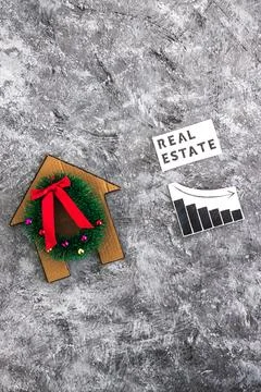 Real Estae text and graph with stats going down next to cardboard house wit.. Stock Photos
