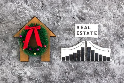 Real Estae text and graph with stats going up and down next to cardboard ho.. Stock Photos