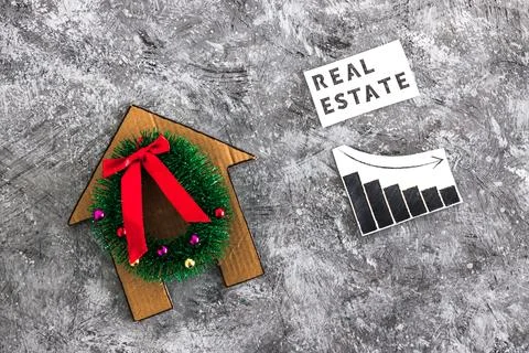 Real Estae text and graph with stats going down next to cardboard house wit.. Stock Photos