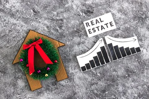 Real Estae text and graph with stats going up and down next to cardboard ho.. Stock Photos