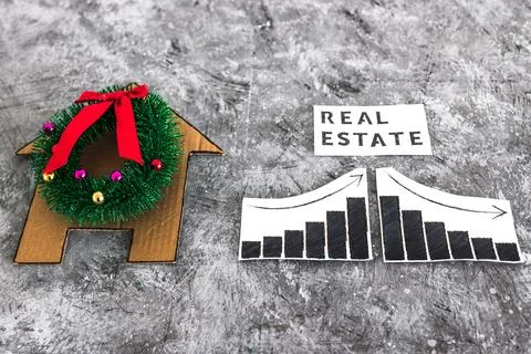 Real Estae text and graph with stats going up and down next to cardboard ho.. Foto stock