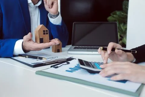 Real estate agent and customer signing contract to buy house, insurance or .. Stock Photos