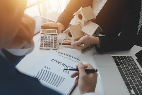 Real estate agent and customer signing contract to buy house, insurance or .. Stock Photos