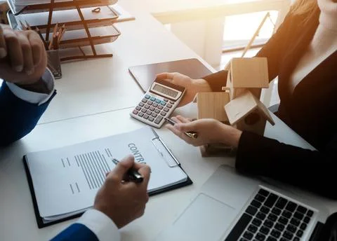 Real estate agent and customer signing contract to buy house, insurance or .. Stock Photos