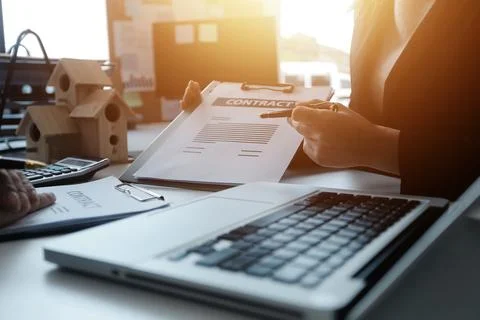 Real estate agent and customer signing contract to buy house, insurance or .. Stock Photos