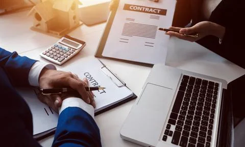 Real estate agent and customer signing contract to buy house, insurance or .. Stock Photos