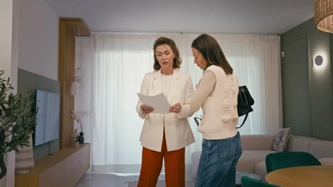 Real estate agent explaining contract details to potential female buyer ins.. Stock Footage 332428090