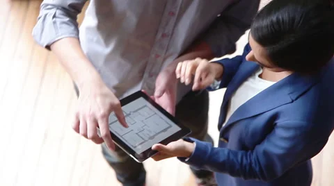 Real estate agent explaining floor plan to woman Stock Footage 63292817