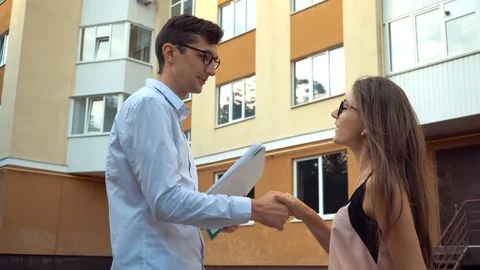 A real estate agent meets with a client near a sale item or leases Stock Footage 111837813