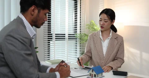 A real estate agent presents a property sale contract to a client Stock Footage 343290037
