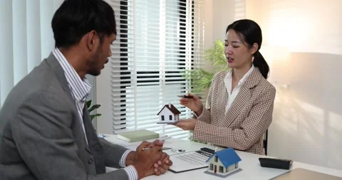 A real estate agent presents a property sale contract to a client Stock Footage 343291041