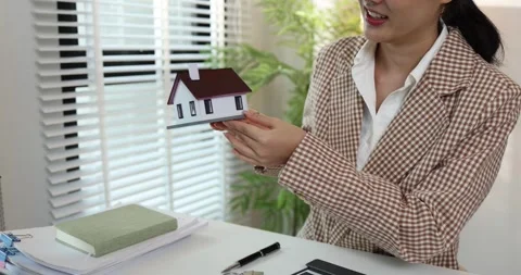 A real estate agent presents a property sale contract to a client Stock Footage 343291259