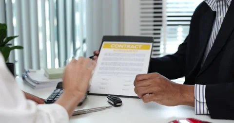 A real estate agent presents a property sale contract to a client Stock Footage 343291704