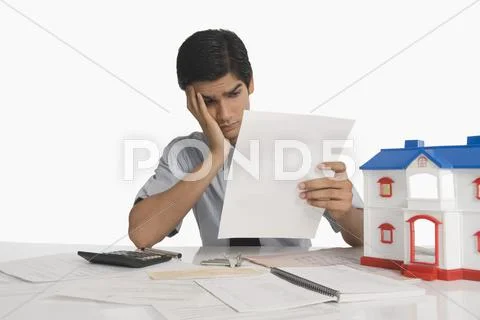 Real estate agent reading a document near a model home Stock Photos