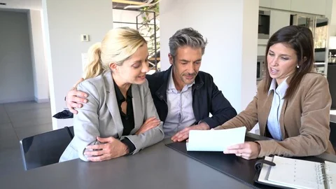 Real-estate agent reading terms of contract to clients Video stock 72738584