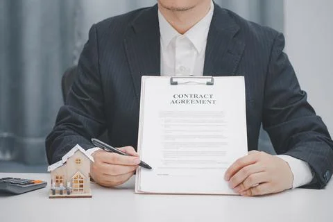 Real estate agent showing contract agreement at office. Home sales and home i Stock Photos