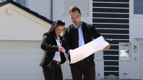 A real estate agent showing a customer house plan Stock-Footage 107719863