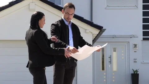 A real estate agent showing a customer house plan Stock-Footage 107721783