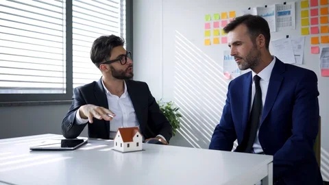 Real estate agent talking with potential client and then signing contracy Stock Footage 114813811