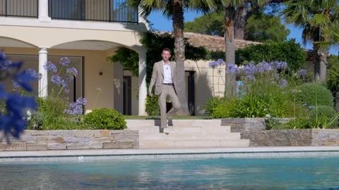 Real estate agent walking down some stairs of a big villa in front of the Stock Footage 220562863
