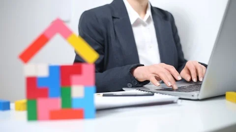 A real estate agent works on a computer and draws up documents  Stock Footage 126006682