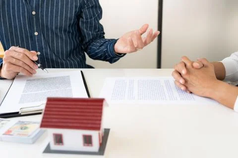 Real estate agents explain the document for customers who come to contact to Stock Photos