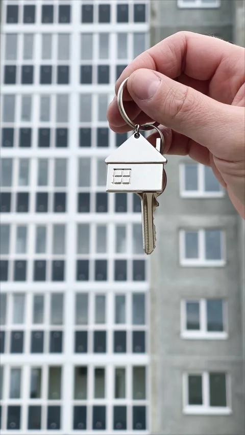 Real estate concept. Hand with keychain in shape of small house and keys. Vertic Stock Footage 306568146