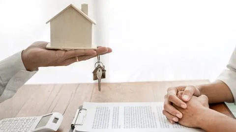 Real Estate developer Agent and sign on document giving keys of new house, .. Stock Photos