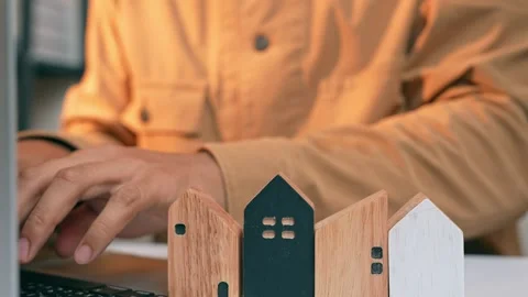 A real estate developer arranges wooden houses. Stock Footage 317600500