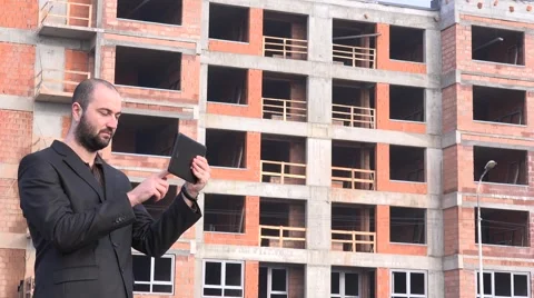 Real estate developer in front of construction site checking tablet thumbs up 4K Stock Footage 58513839