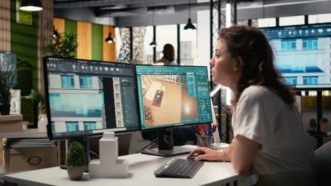Real estate developer reviews architectural layouts on dual monitors Stock Footage 316795084