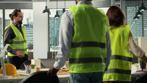 Real estate developers and architects in a modern office reviewing blueprints Stock Footage 320031314